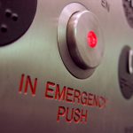 A close up shot of an emergency stop button on an elevator